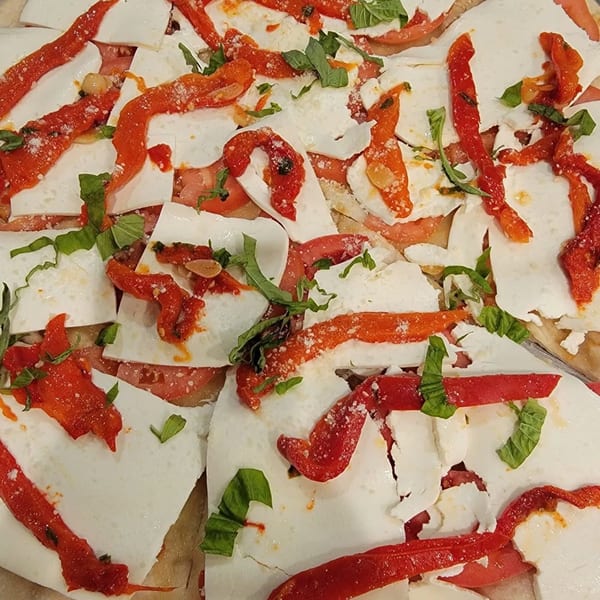 Sayville Pizza's white pizza with fresh mozzarella, roasted red peppers, and basil.